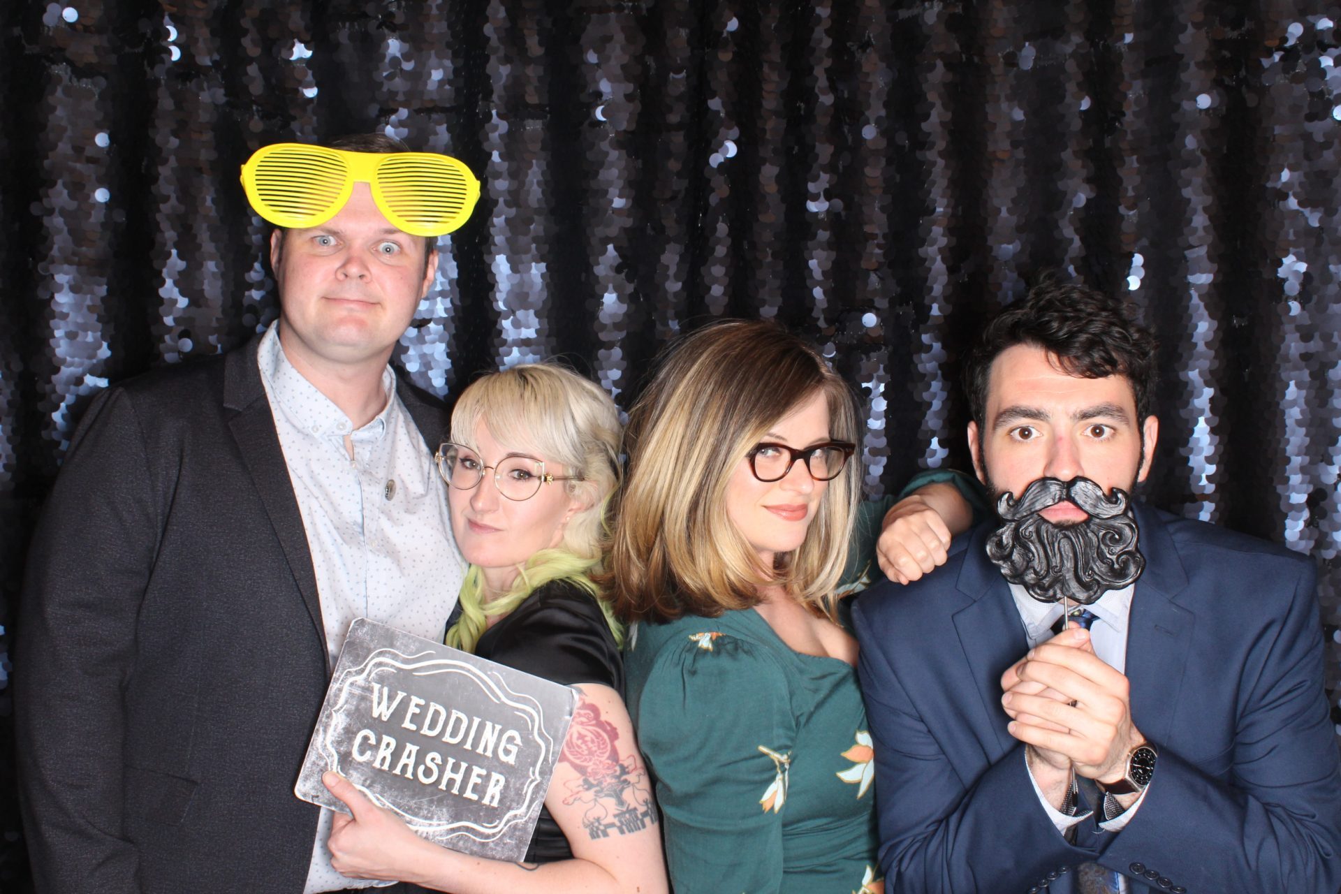 A Group of Friends Taking Picture with Props From Selfie Booth